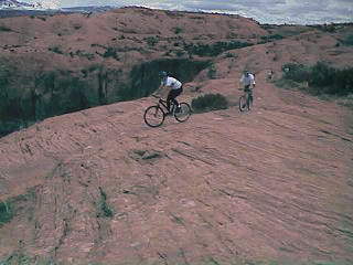 Bikers cross the vast expanses of Navajo sandstone